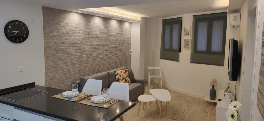 een woonkamer met een bank en een klok aan de muur bij Rual Centro apartamento in Ronda