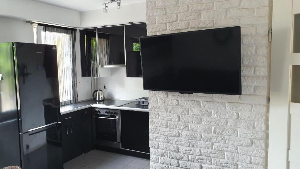 a kitchen with a tv on a brick wall at Apartament New Jork in Olsztyn