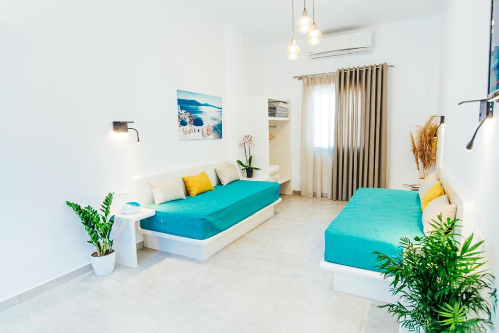 a living room with two blue couches and plants at Floresita apartment in Fira