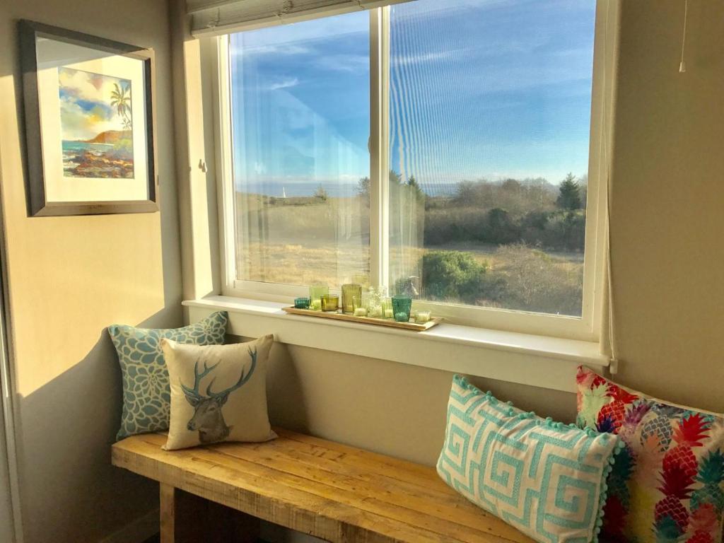 una ventana con almohadas y un banco frente a ella en Vista Del Mar Condo - Oyhut Bay Seaside Village en Ocean Shores