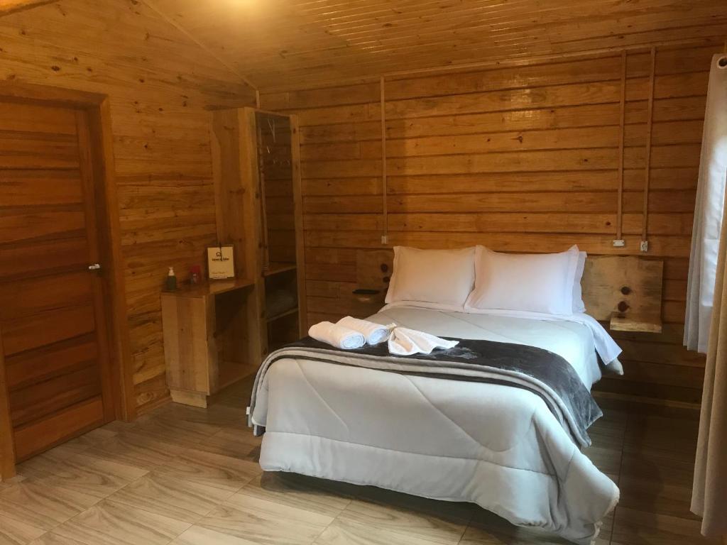 een slaapkamer met een bed in een houten kamer bij Cabana da Colina in Bom Jardim da Serra