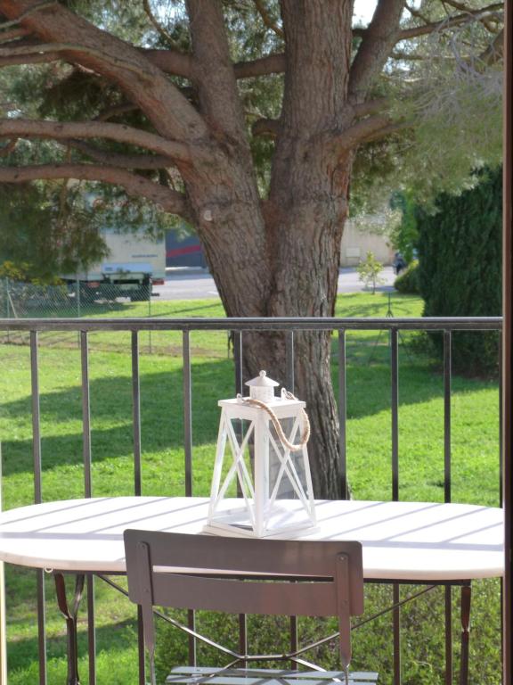 a table with a light on it next to a tree at AGRÉABLE STUDIO cabine PROCHE MER in La Londe-les-Maures
