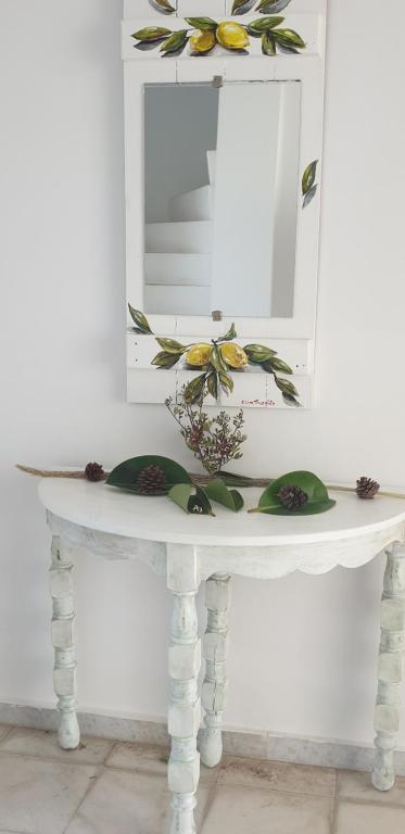 a white table with a mirror and flowers on it at Hotel Anezina in Drios