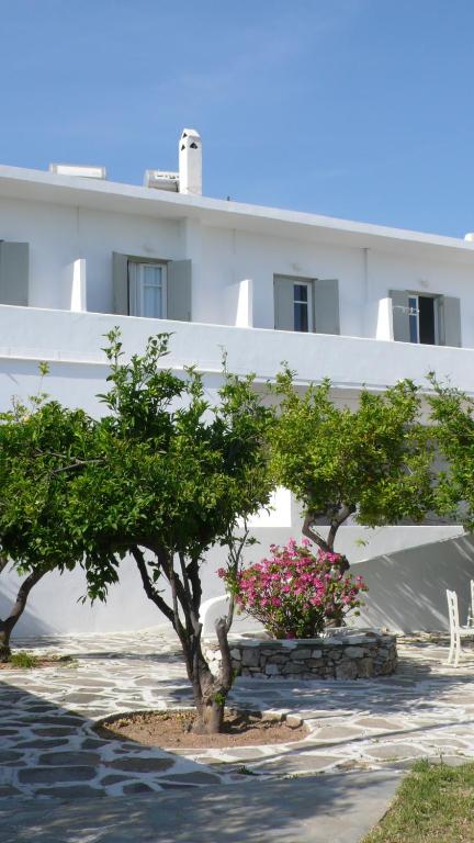 two trees and flowers in front of a building at Hotel Anezina in Drios