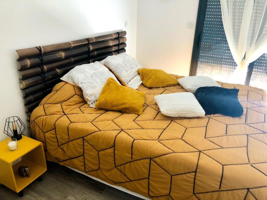 una cama con almohadas en una habitación en La Croisée Chambre d hôte avec sanitaires partagés, en Guéreins