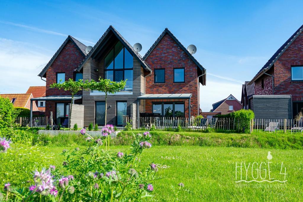a house in a field of grass with flowers at Ferienhaus Hygge4 in Carolinensiel