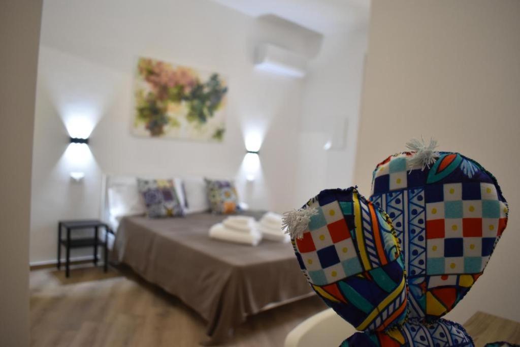 Cette chambre comprend un lit et une table avec un vase. dans l'établissement b&b Lastracu, à Castellammare del Golfo