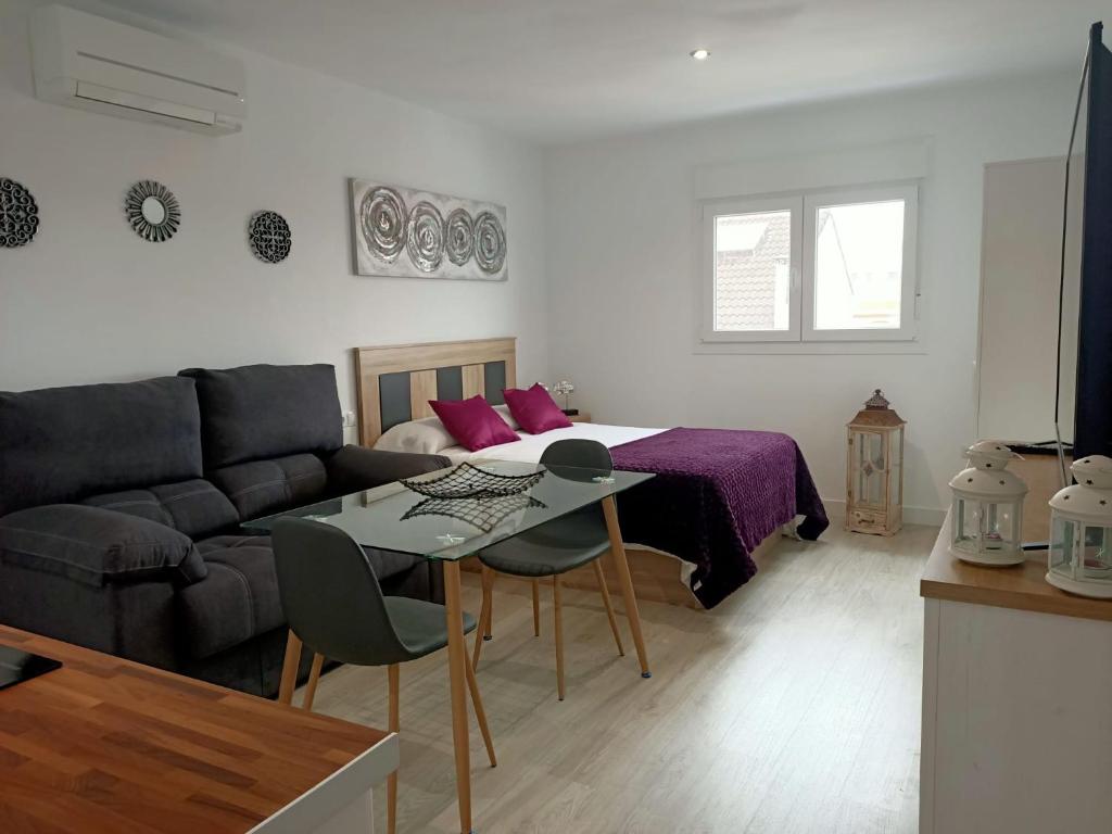 sala de estar con cama, mesa y sofá en Apartamentos NayDa studio 1 en Mérida