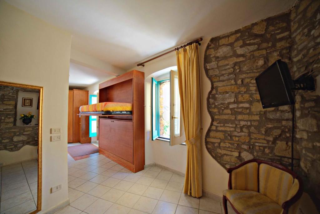 sala de estar con pared de piedra y silla en Il Fascino del Borgo, en Castellabate