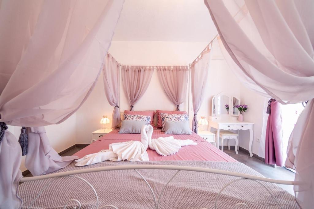 1 dormitorio con cama rosa y dosel en Villa Katarin en Komiža