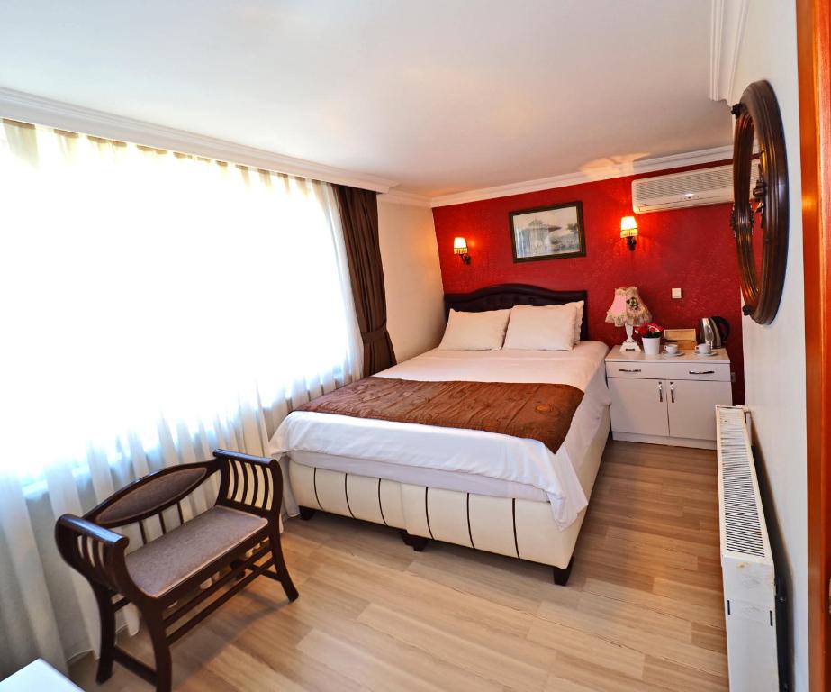 Un dormitorio con una cama grande y una silla. en The Sunrise Hotel, en Estambul