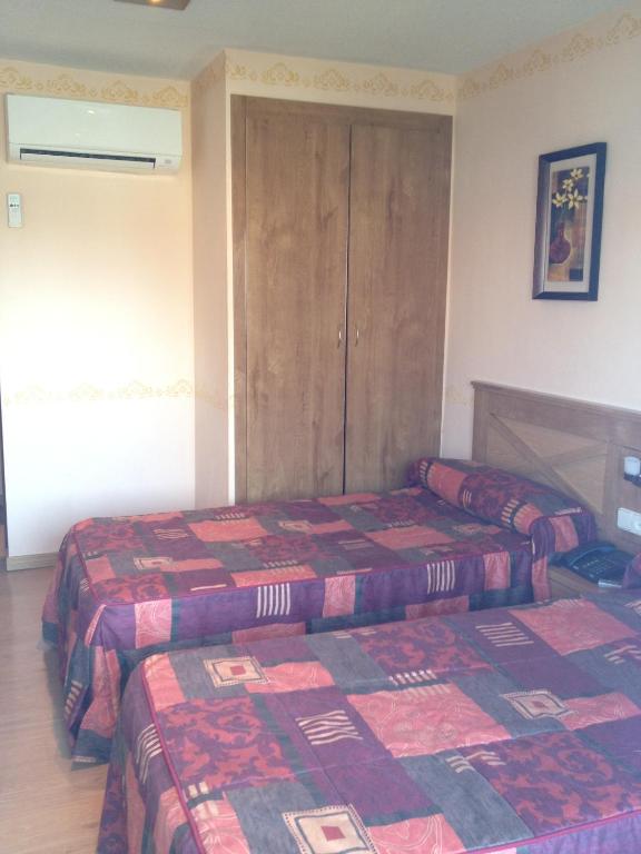 A bed or beds in a room at Hotel Don Angel