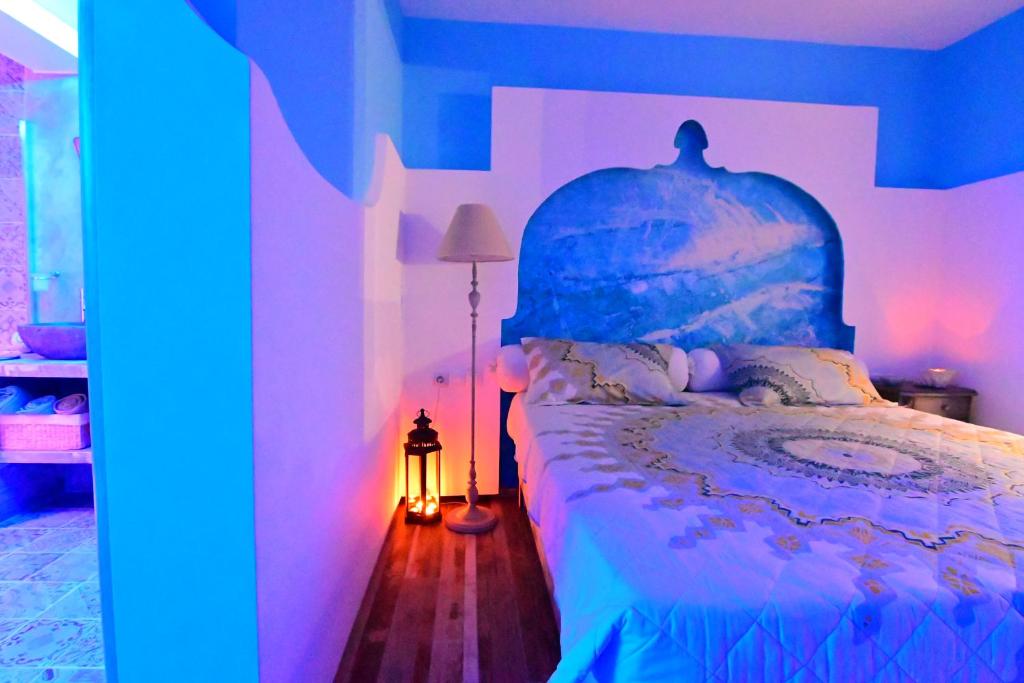 a bedroom with a blue and white bed and a lamp at Alisaxni Studios in Argassi