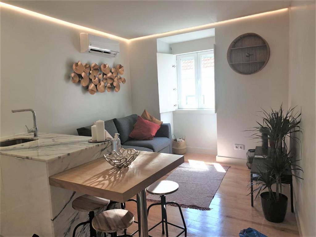 eine Küche und ein Wohnzimmer mit einem Tisch und einem Sofa in der Unterkunft Principe Real Central Home in Lissabon