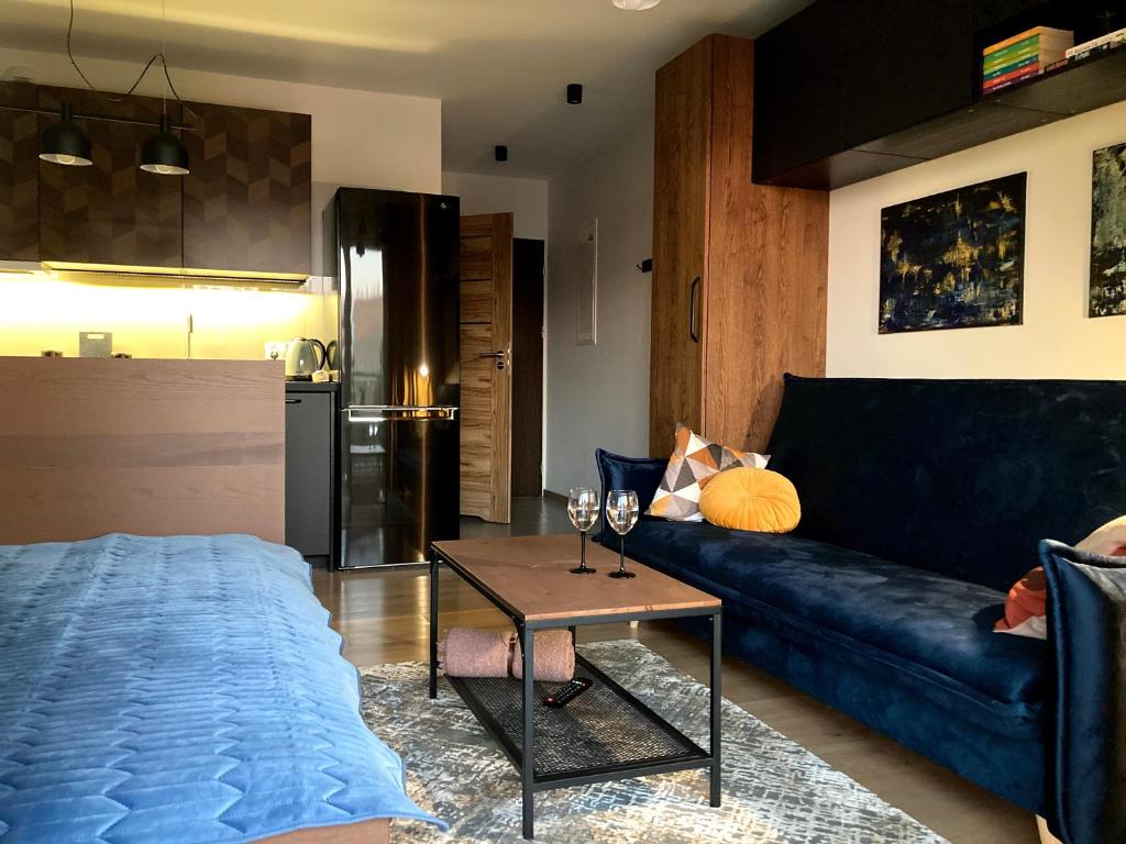 a living room with a blue couch and a table at Apartament Centrum Bocian in Białystok