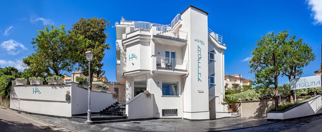 un edificio blanco con escritura azul en él en Hotel Angelina en Sant'Agnello