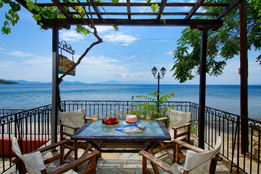 una mesa y sillas en un balcón con vistas al agua en Iro family apartments pelion, en Lefokastro