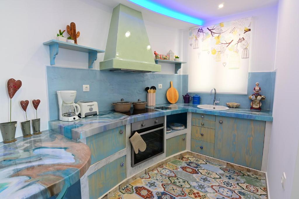 a kitchen with blue and white cabinets and a sink at Alisaxni Studios in Argassi