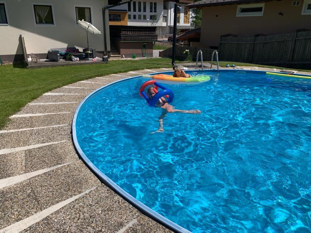 two people playing in a swimming pool with a frisbee at Appartement STOA in Kleinarl