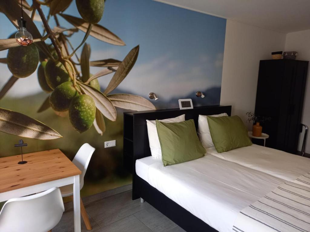 een slaapkamer met een bed en een tafel en een plant bij Os Mundos in Deurne