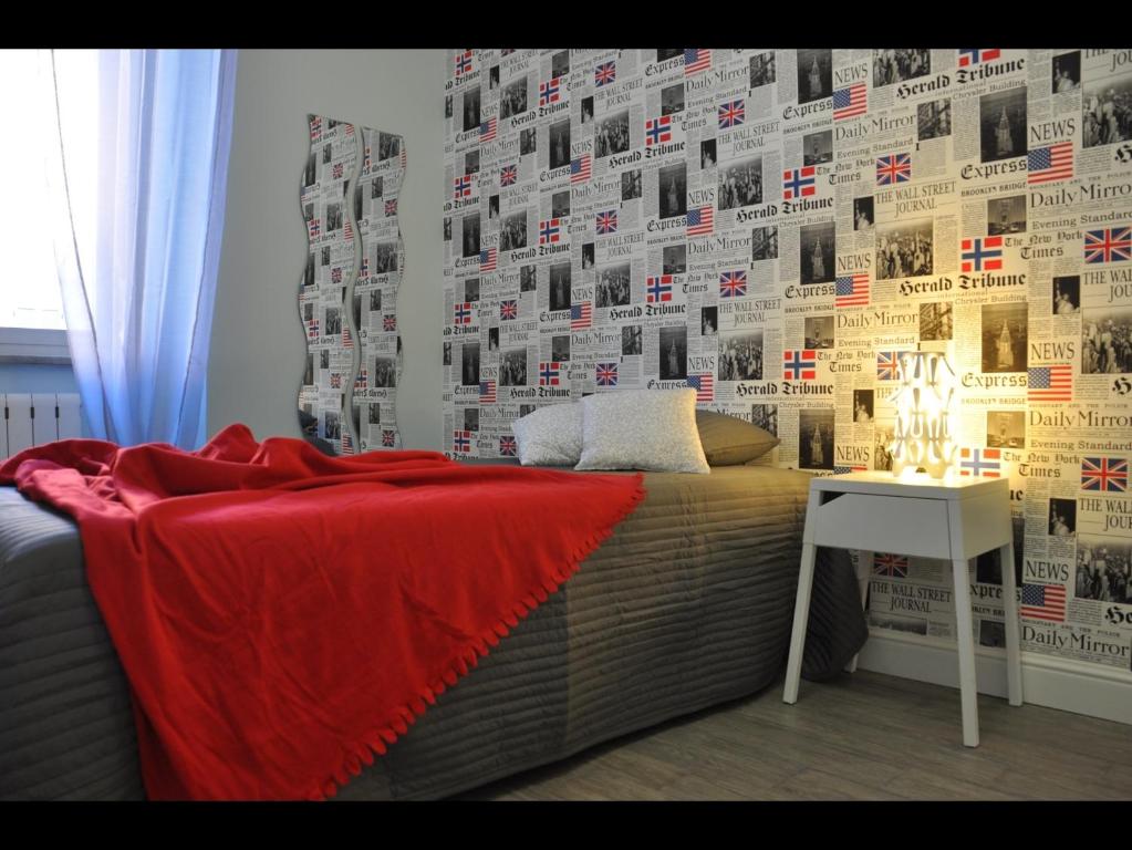 um quarto com uma cama com um cobertor vermelho e uma secretária em Just Colosseum Suite em Roma