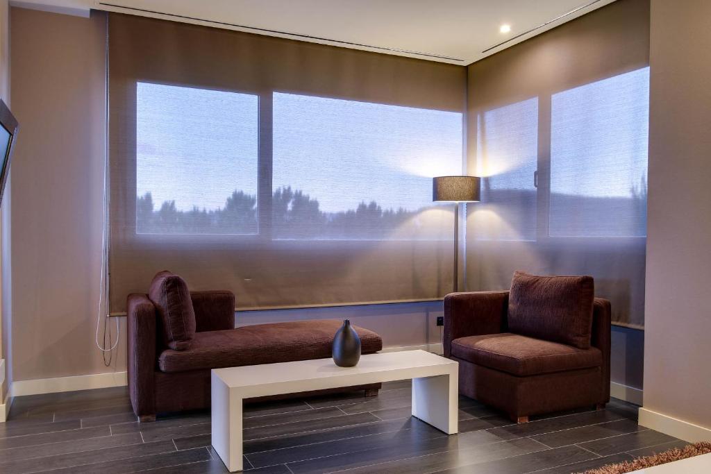 a waiting room with two chairs and a table and a window at PCM Forum Alcalá in Alcalá de Henares