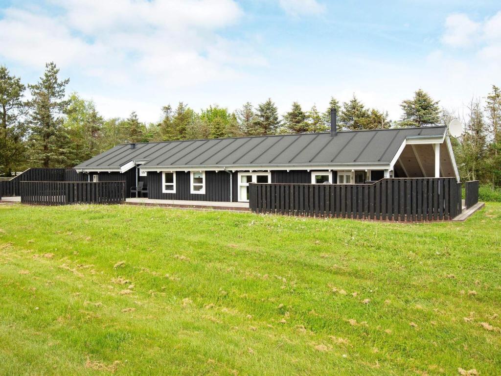 een zwart huis met een zwart dak bij 9 person holiday home in Jerup in Jerup