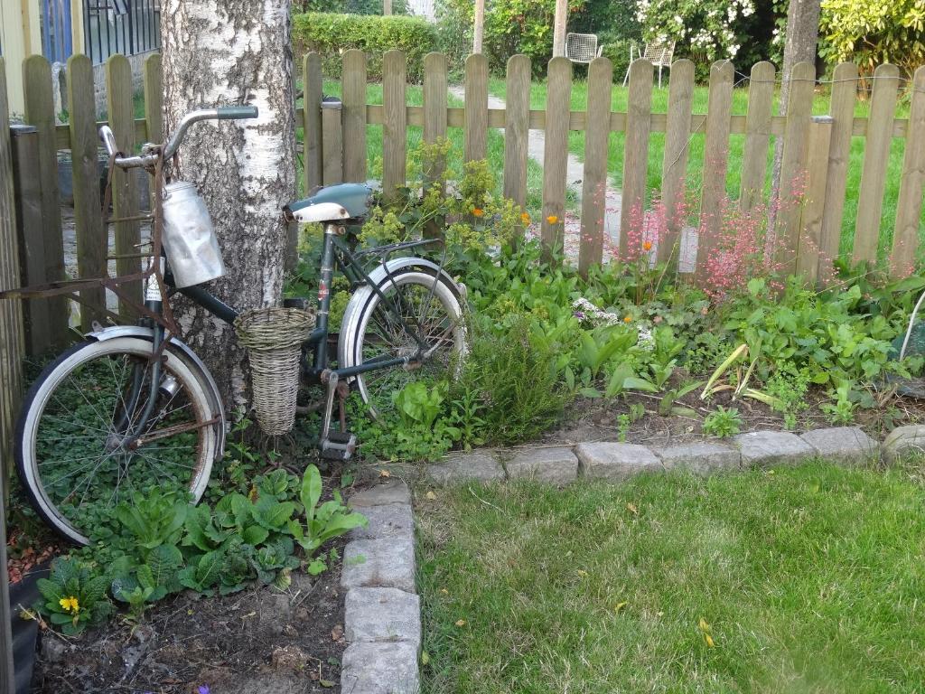 a bike parked next to a tree in a garden at Apartment De Paprente in Merkem