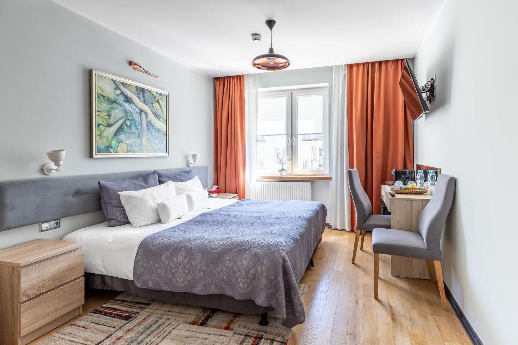 1 dormitorio con cama, escritorio y silla en Apartamenty Efekt 72 en Gdynia