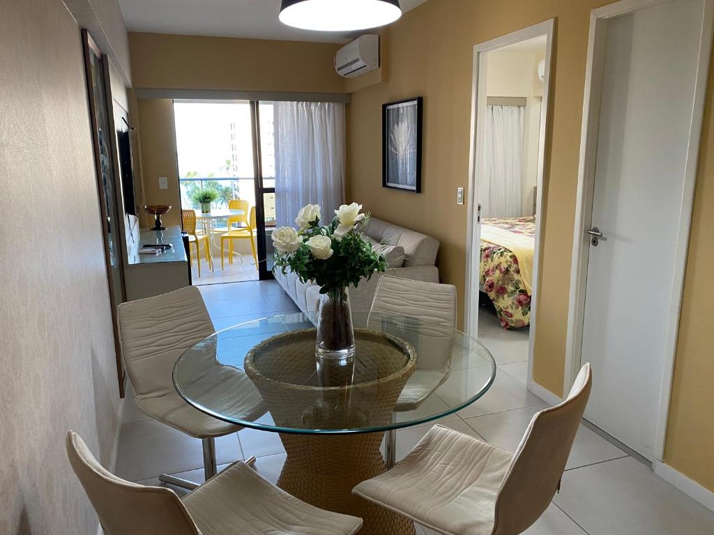 a dining room with a glass table and chairs at Apto Top Custo-Benefício Qualidade e preço que surpreendem in Maceió