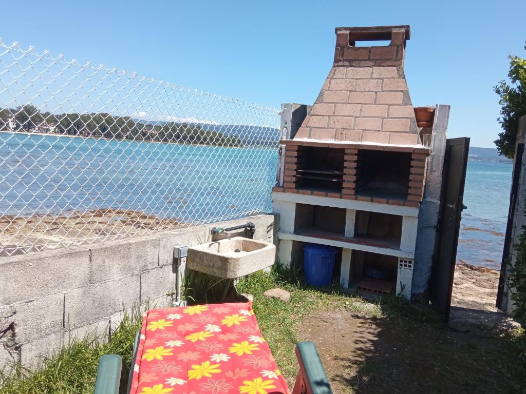 a building with a sink next to the water at Vistas Al Mar E Isla De La Toja in O Grove