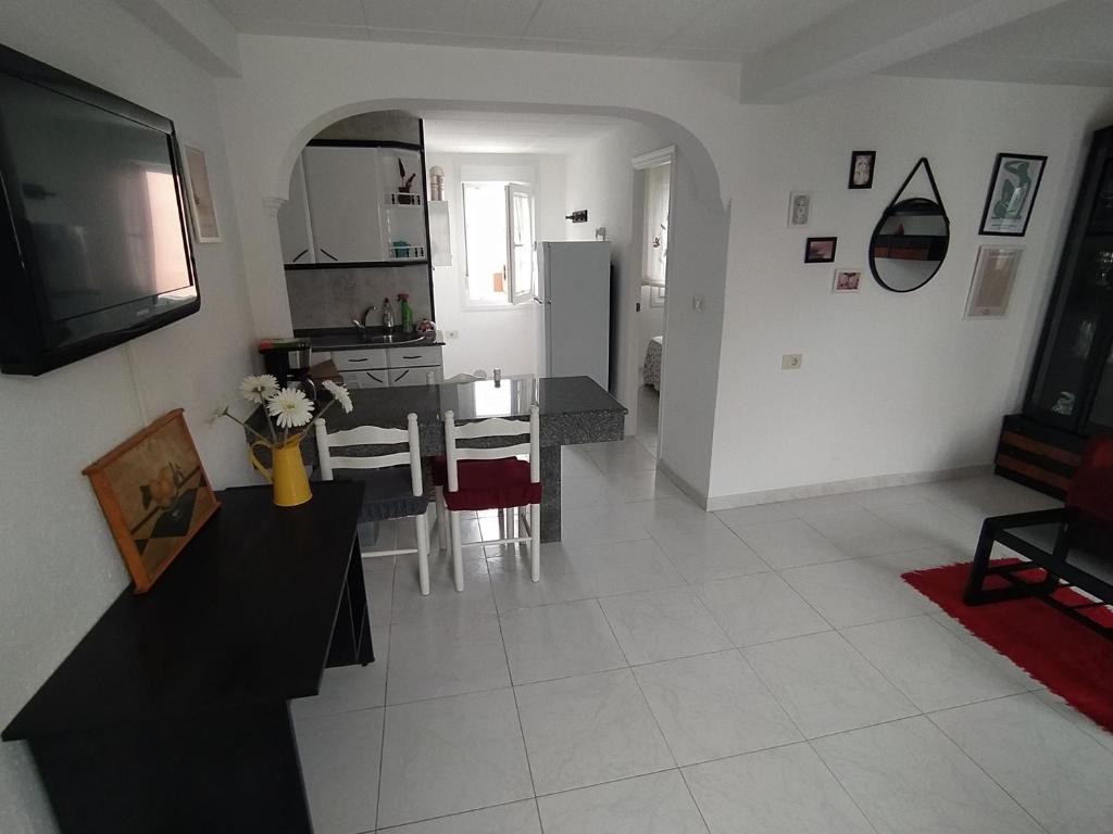 a kitchen and living room with a table and a tv at Apartamento en primera línea de playa in Laxe