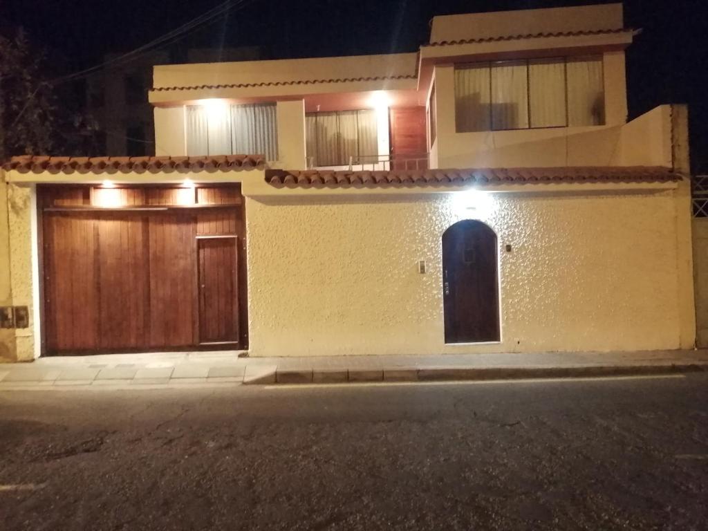 una casa con dos puertas de garaje por la noche en La Casa de Leonardo YANAHUARA, en Arequipa