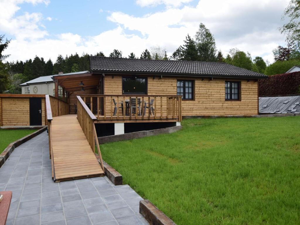 a log home with a deck and a house at Cosy chalet in Durbuy in a beautiful hiking area in Durbuy
