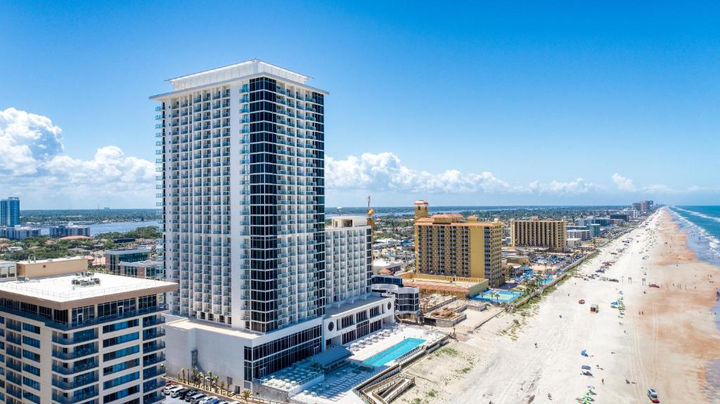 z góry widok na wysoki budynek obok plaży w obiekcie Daytona Grande Oceanfront Resort w mieście Daytona Beach