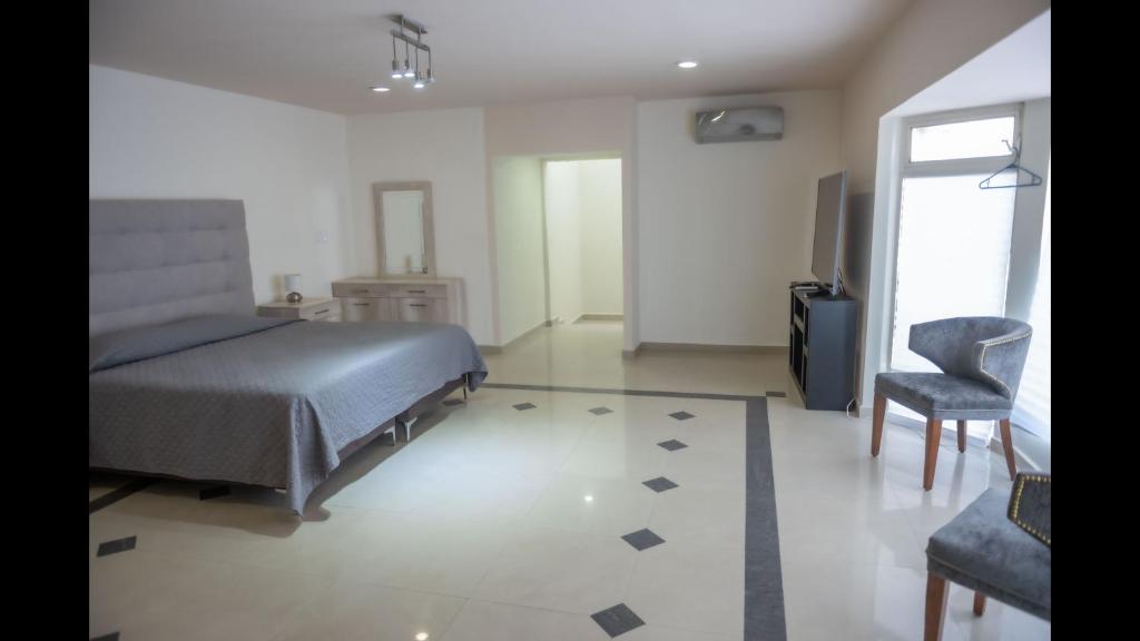 um quarto com uma cama e uma cadeira em Room in Guest room - 22 Suite for two people em Torreón