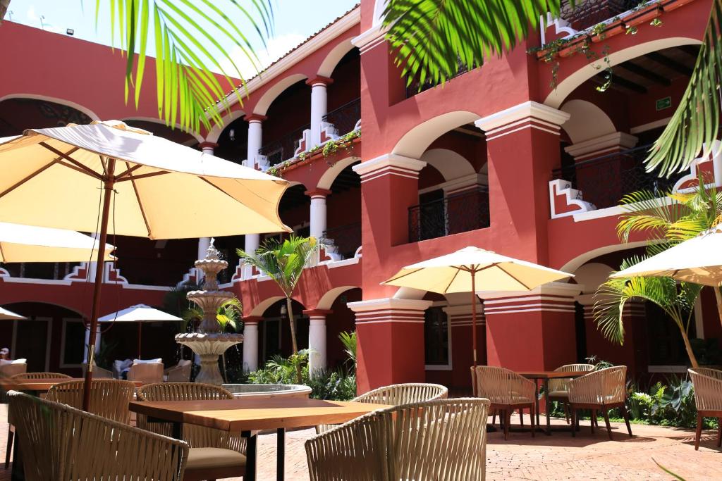 Jala的住宿－Nukari Quinta Boutique，大楼前的餐厅,配有桌子和遮阳伞