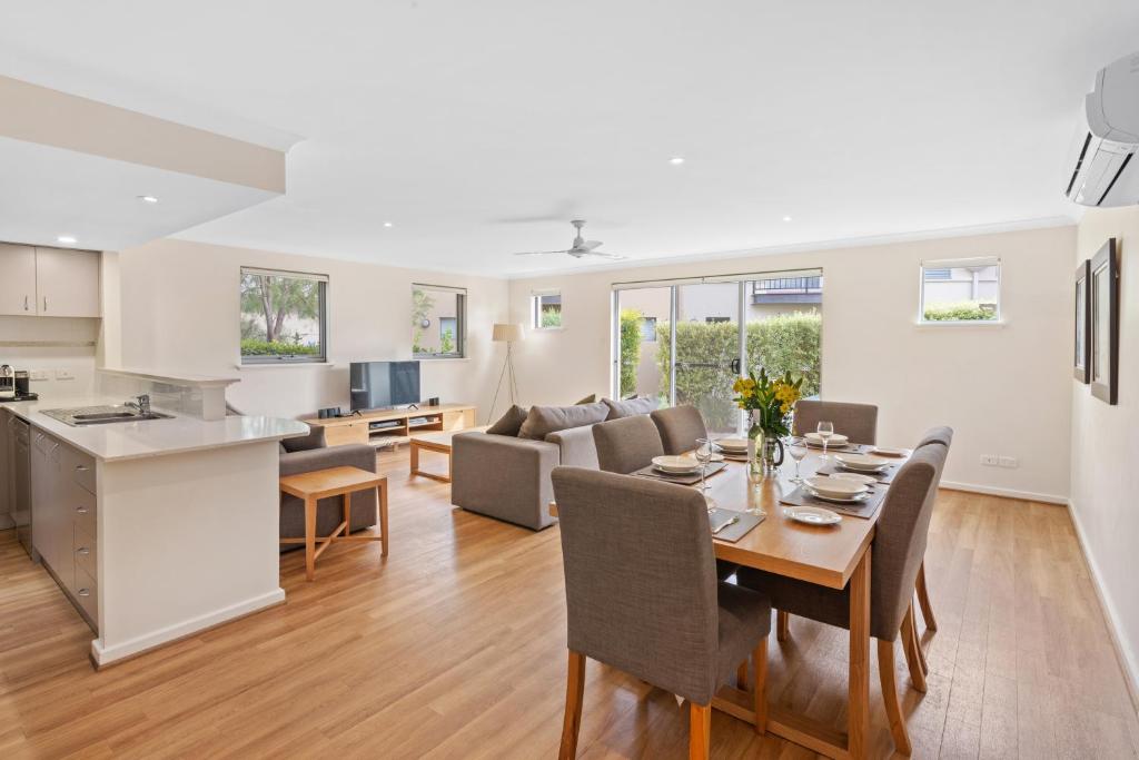 a kitchen and a living room with a table and chairs at 68@CapeView in Busselton