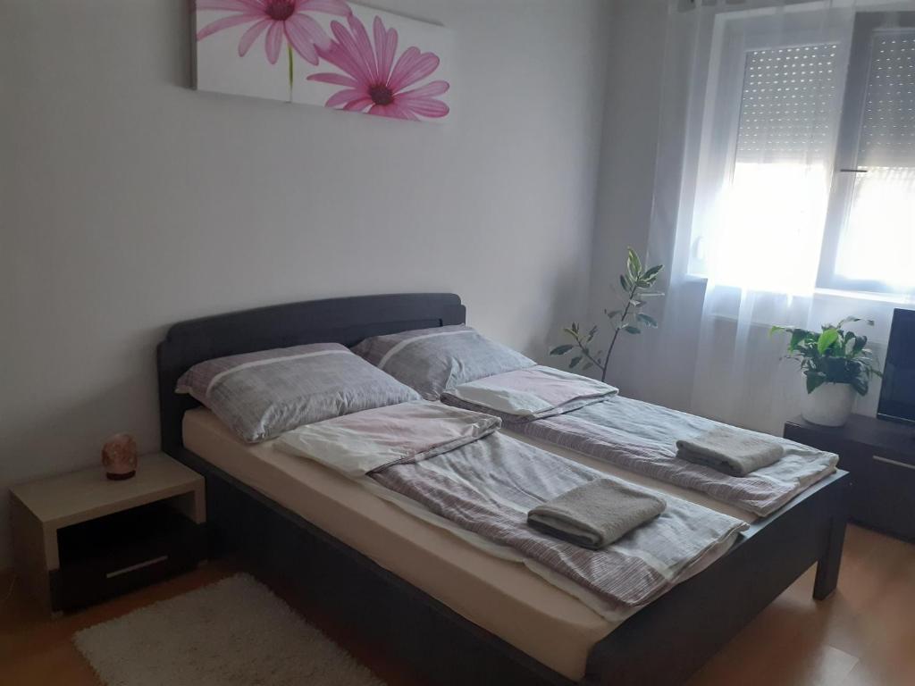 a bed with two pillows on it in a bedroom at Tukán Apartman Hajdúszoboszló in Hajdúszoboszló