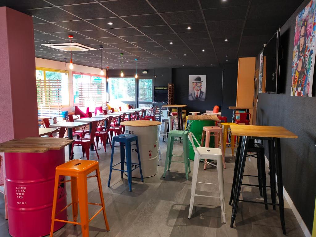 um restaurante com mesas e bancos coloridos em Urban Style Arl HOTEL em Arles