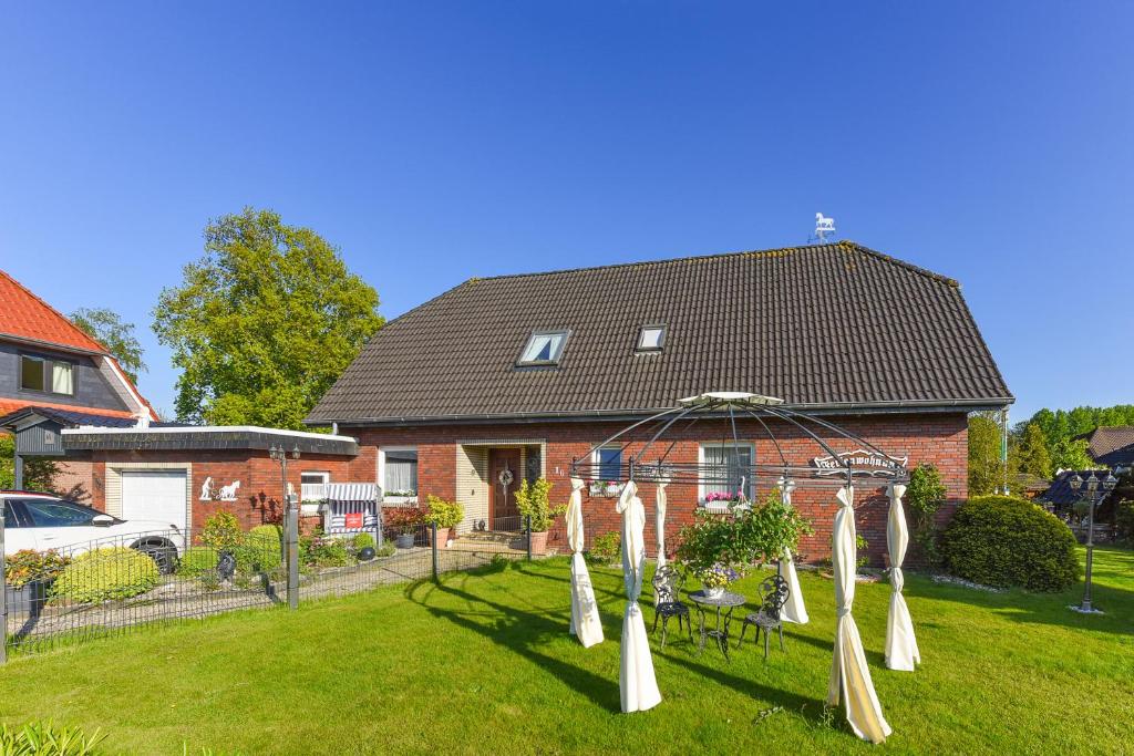 a house with a garden with a gazebo at Haus Sonne & Meer in Esens