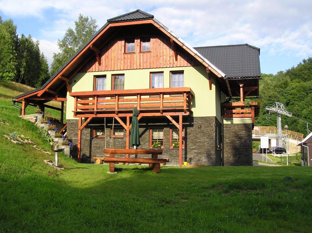 a large house with a bench in front of it at Apartmány U Lanovky in Rokytnice nad Jizerou