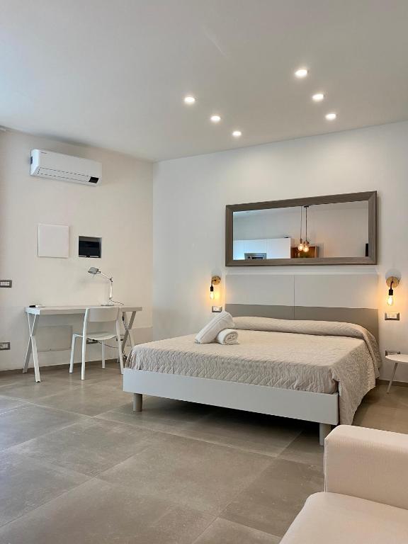 a bedroom with a bed and a desk and a mirror at Enjoy Olbia in Olbia