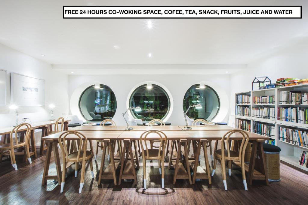 a large table in a library with chairs and mirrors at Blu Monkey Hub and Hotel Phuket Town- Free All Day Coworking space in Phuket Town