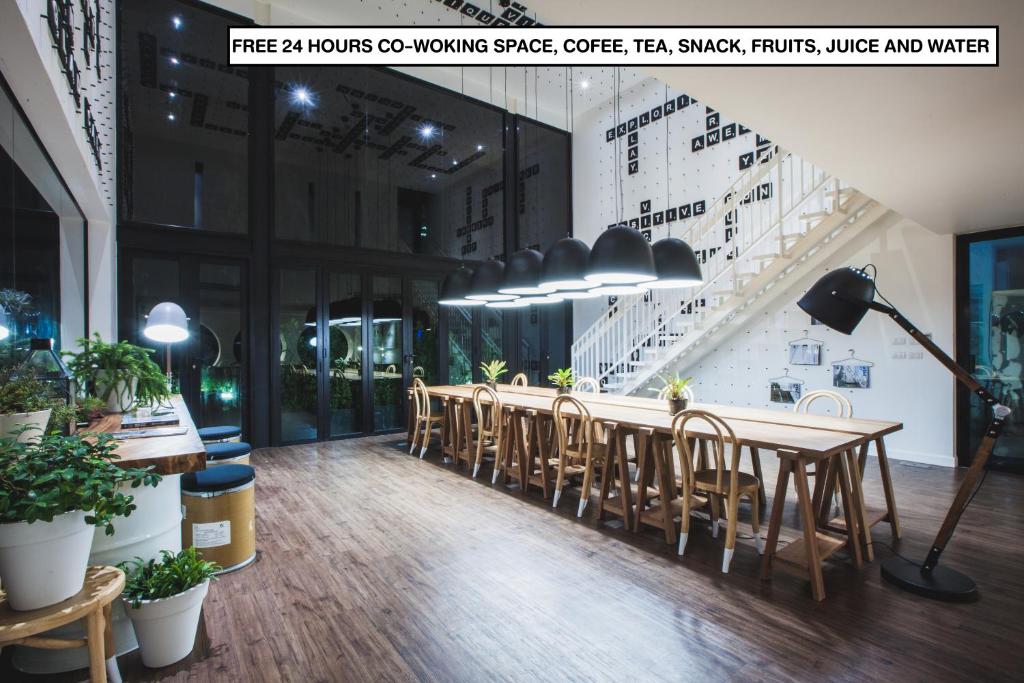 a restaurant with a long table and chairs at Blu Monkey Hub and Hotel Phuket Town- Free All Day Coworking space in Phuket Town