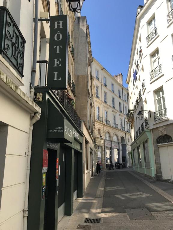 una calle con edificios y una señal para una tienda en Hôtel Saint-Patrick, en Nantes