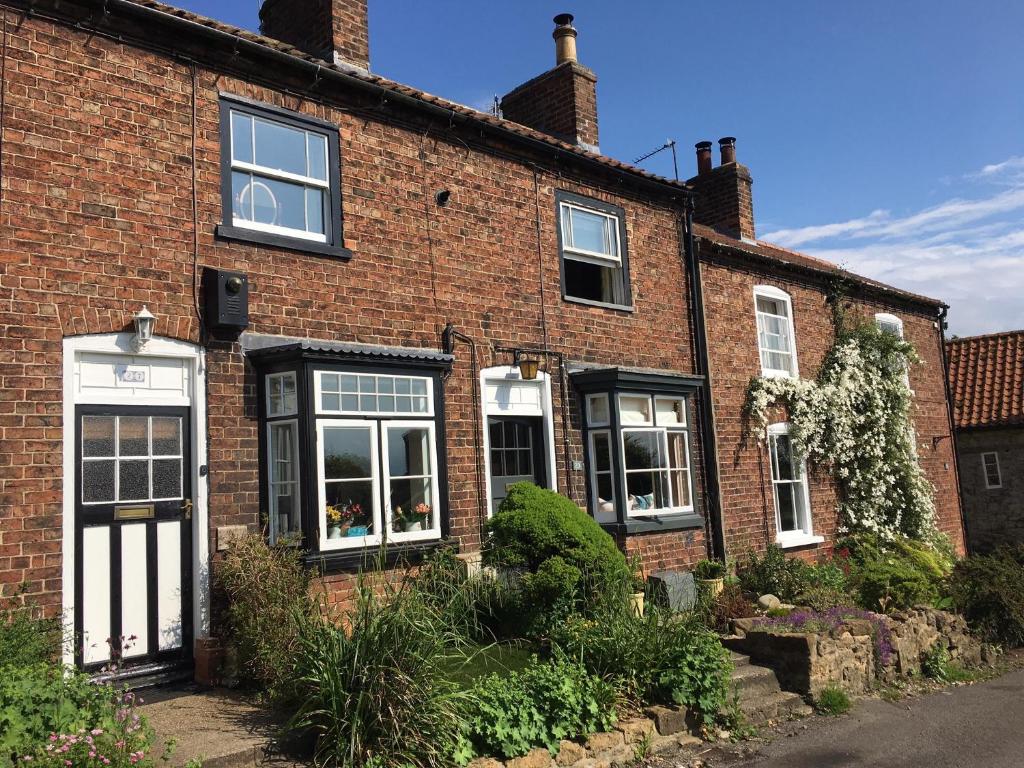 a red brick house with black and white windows at Cosy Lincs Wolds cottage in picturesque Tealby in Tealby