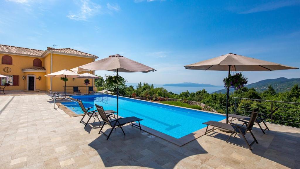 basen z leżakami i parasolami w obiekcie Apartments Villa BV w mieście Opatija