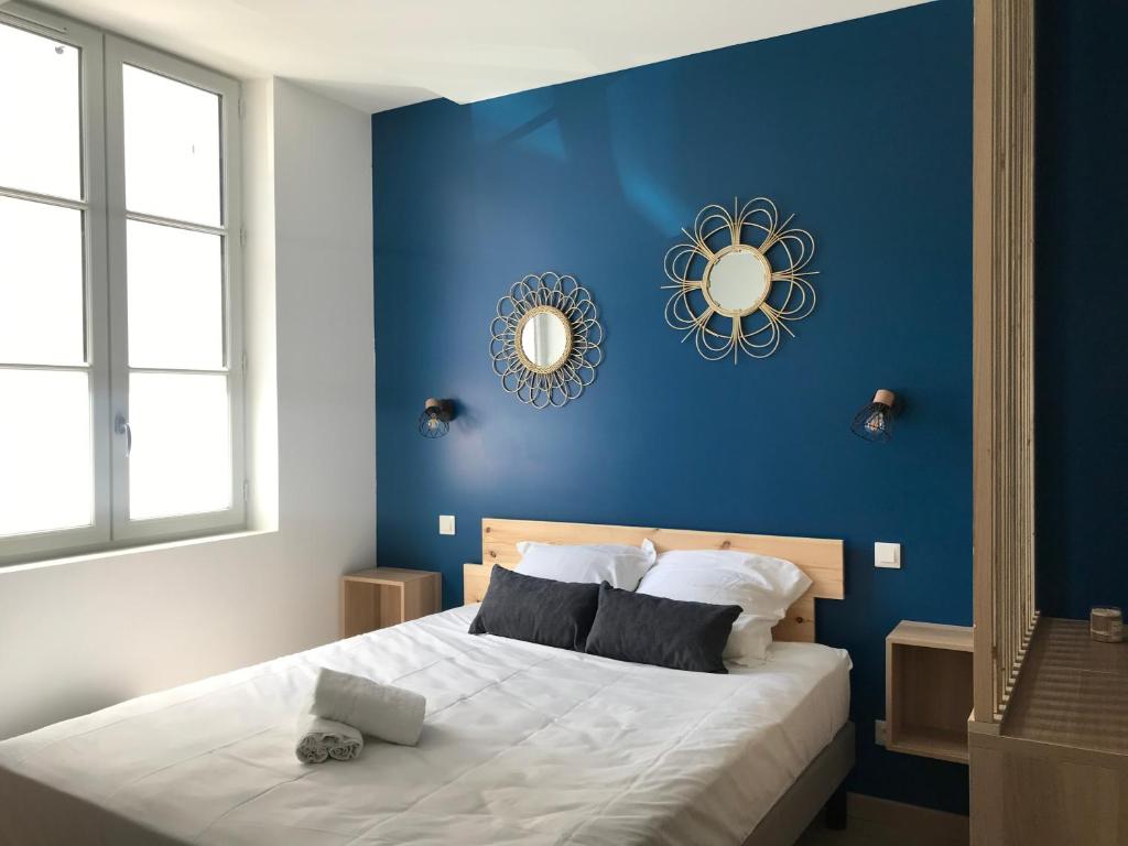 een blauwe slaapkamer met een bed met een blauwe muur bij Riva Lodge in Saint-Aignan