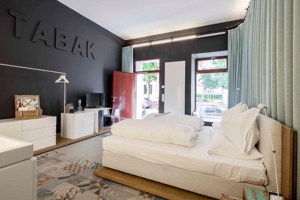 sypialnia z białym łóżkiem i czarną ścianą w obiekcie grätzlhotel beim Belvedere w Wiedniu